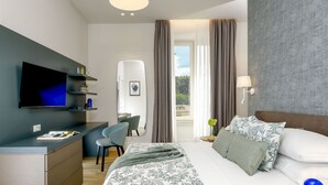A modern hotel room with a bed, a desk, a TV, and a balcony with curtains. - Domus Augustea - Augusto (Roma)