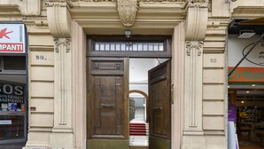 A building entrance with ornate architectural details, a wooden door, and a staircase leading inside. - Domus Augustea - Augusto (Roma)