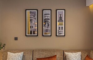 Un mur orné de trois tableaux représentant des structures architecturales.