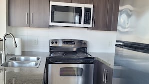 A modern kitchen with stainless steel appliances, a microwave, oven, and refrigerator.