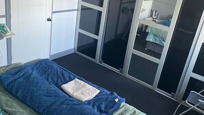 A bedroom with a bed, a wardrobe, and a sliding door leading to a bathroom. - super king size bed room with cozy and big bed for 3 in fmaily home (Hornchurch)