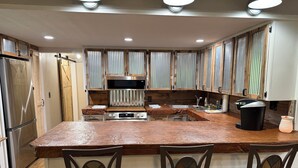 A kitchen with a central island, wooden cabinets, a built-in oven, and a sink. - 3+bed 3 bath w/2 slip covered dock,on a cove in Duck Creek parking for trailers (Afton)