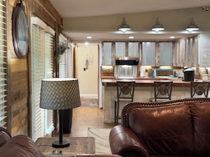A modern living room with a leather sofa, a patterned floor lamp, and a wooden coffee table. - 4 bed 3 bath 2 slip covered dock,on a cove in Duck Creek parking for trailers (Afton)