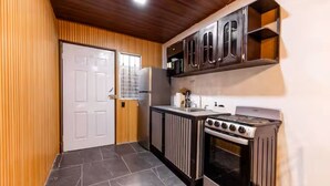 A compact kitchen with a stove, oven, and built-in cabinets.