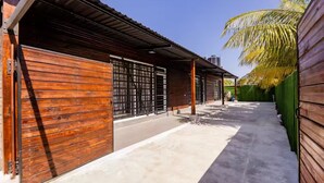A building with wooden exterior walls, large garage doors, and a concrete pathway.