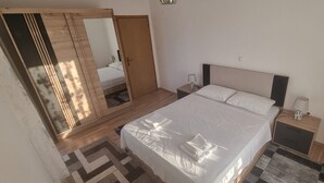 Un dormitorio con cama, mesitas de noche, un espejo y un armario.