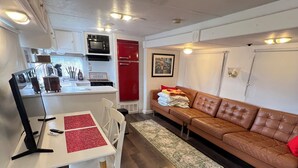 Ein kompakter Wohnbereich mit Küchenzeile, Essbereich und einer Sitzecke mit Sofa.