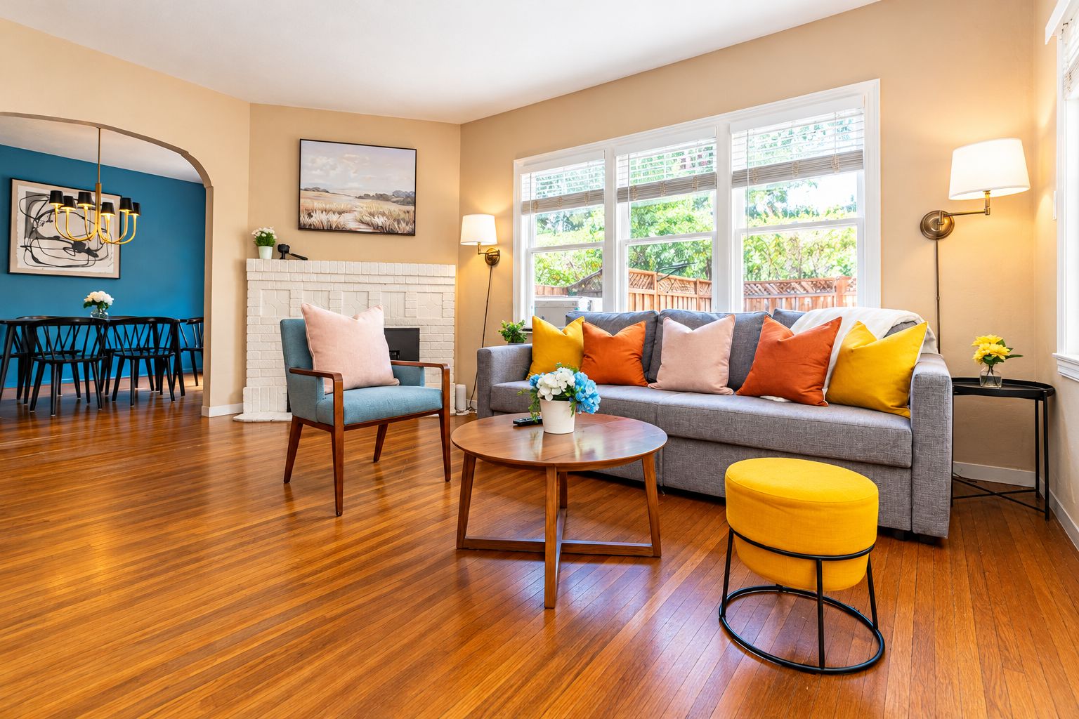 A living room with a sofa, armchairs, a coffee table, and a dining area with chairs and a table.
