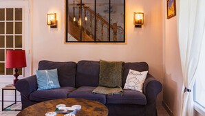 Un salon avec un canapé, une table basse, une lampe et un tableau encadré au mur.