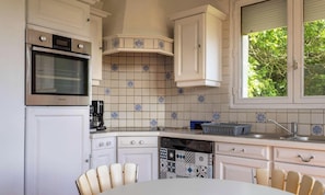 A kitchen with white cabinets, a Samsung oven, a coffee maker, and a dishwasher. - Cozy house for 9 people between beach and nature (FREHEL)