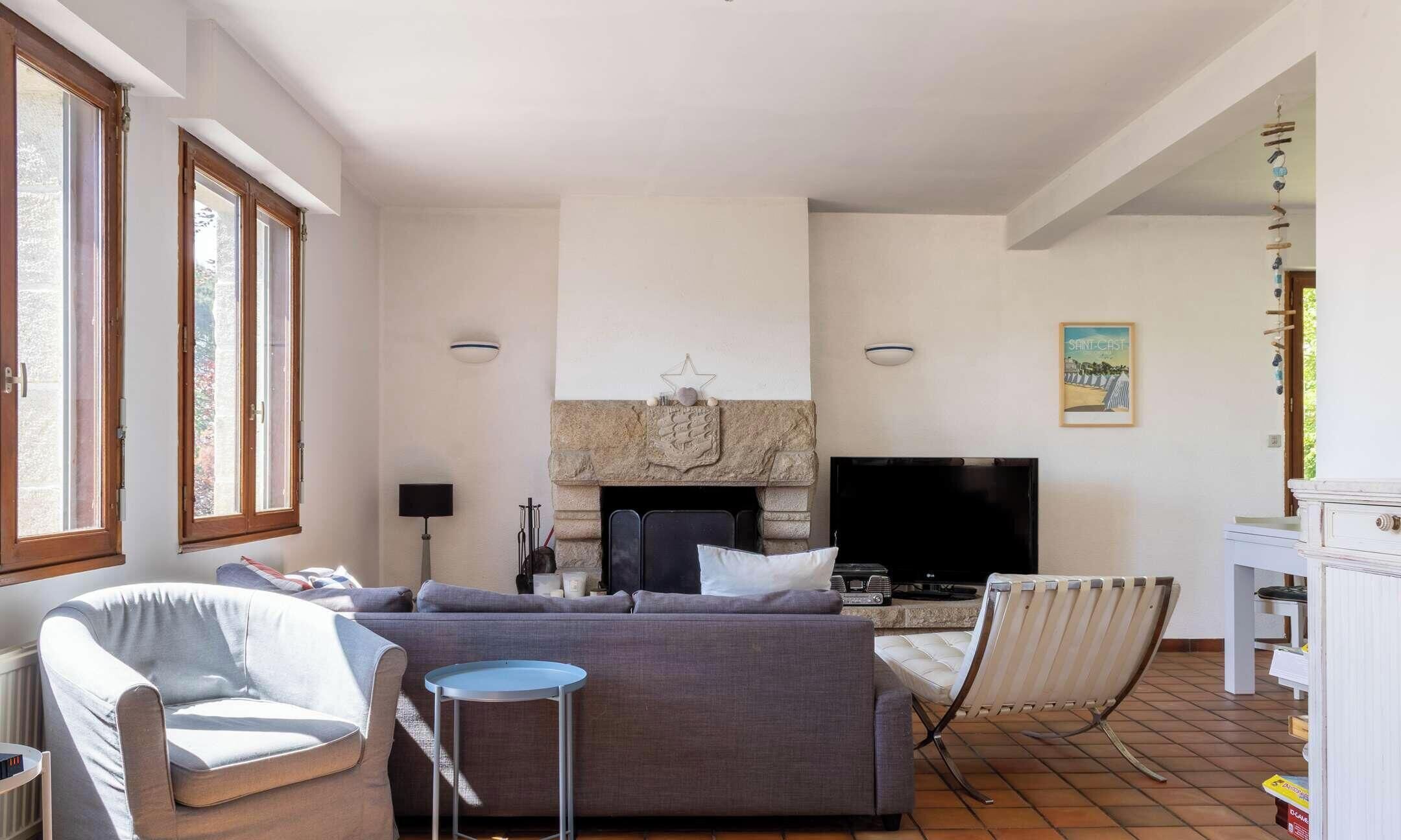 A living room with a fireplace, a television, and a sofa.