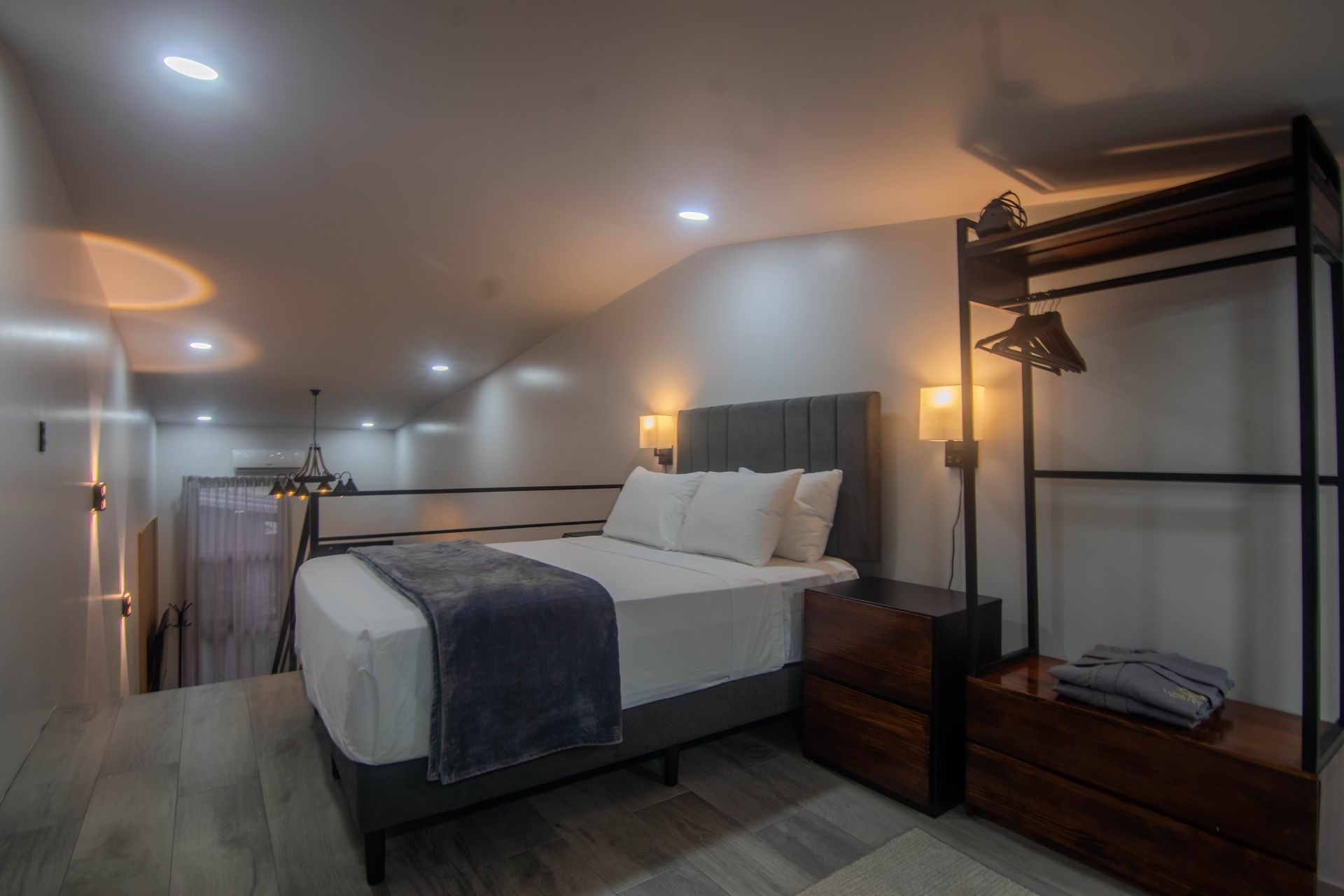 A modern bedroom with a bed, bedside tables, and a wardrobe.