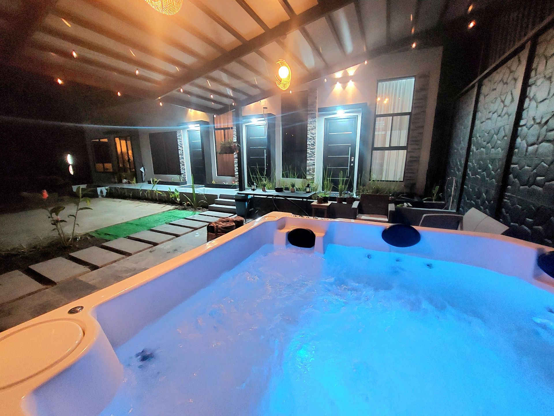 Un jacuzzi con pared de piedra y ventanas al fondo.