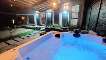 Un jacuzzi con pared de piedra y ventanas al fondo.