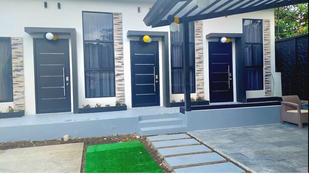 A modern house with three doors, a covered porch, and a small garden area. - Brand new Luxury Suites w/ jacuzzi. (El Castillo)