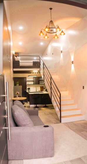 A modern interior with a staircase, a kitchen, and a seating area. - New! Luna Negra Luxury Suites & Spa. Your romantic getaway in Arenal (El Castillo)
