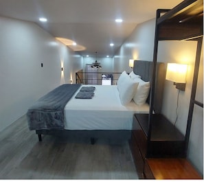 Ein modernes Hotelzimmer mit einem Bett, Nachttischlampen und Blick auf die Stadtlandschaft.