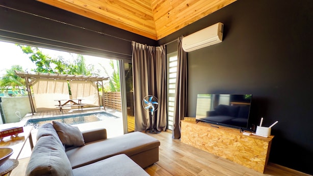 A modern living room with a sofa, a TV, and a wooden entertainment unit.