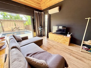 Un salon moderne avec un canapé, un téléviseur et un plancher en bois.
