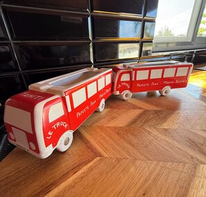 Zwei Spielzeug-Feuerwagen auf einem Holzboden, im Hintergrund ein Fenster.