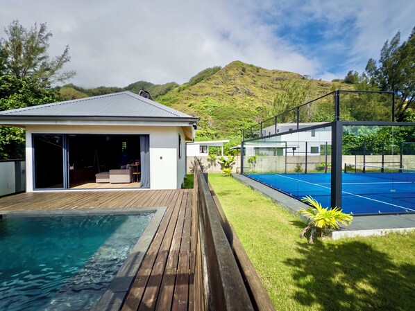 Et moderne hus med swimmingpool, tennisbane og bjergudsigt.