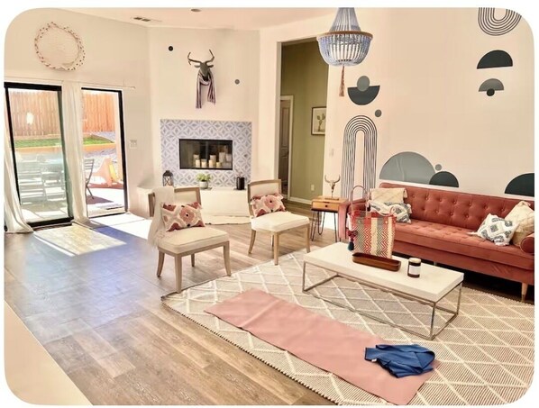 A living room with a sofa, chairs, a coffee table, and a fireplace. - The Dreamcatcher with Game Room, Jacuzzi, pooltable, cowboy jacuzzi and foosball (Joshua Tree)
