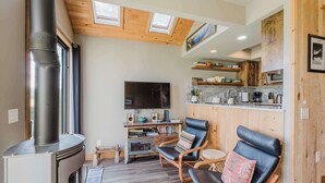 Een gezellige woonkamer met een open haard, een televisie en comfortabele zitplaatsen.