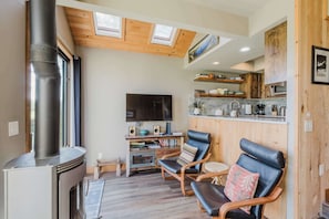 A cozy living room with a fireplace, a television, and comfortable seating. - Lakeview Meadow Retreat (Sisters)