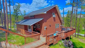 A wooden cabin with a deck, surrounded by trees and a clear sky. - The Buckhorn Lodge in Custer (Custer)