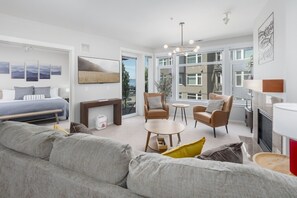 Ein modernes Wohnzimmer mit einer Couch, Sesseln, einem Couchtisch und einem Kamin.