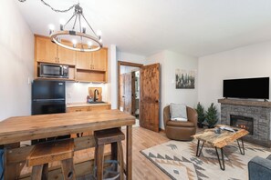 A modern kitchen with wooden cabinets, a built-in microwave, and a black refrigerator. - New! Cozy Condo at Marina Cay | Flathead Lake, Glacier & Bigfork Village (Bigfork)
