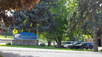 A parking lot with several cars, a sign for 'Marina Cay,' and surrounding trees.