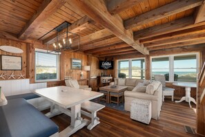 Ein Holzinnenraum mit Esstisch, Sofa und Fernseher.