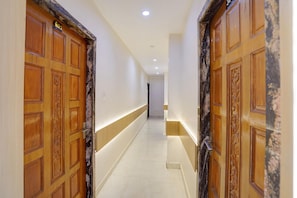 A hallway with wooden doors and a light-colored floor. - Classic Hotel O Kanpur City Centre (Kanpur)