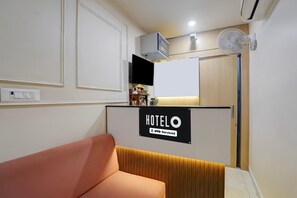 A hotel reception area with a sign indicating it is OYO-serviced.