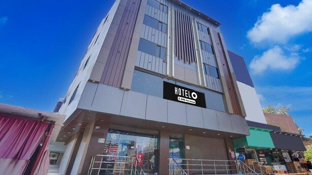 Un hôtel moderne, reconnaissable à son grand panneau lumineux indiquant « HÔTEL ».