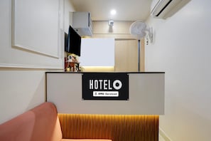 A hotel reception area with a sign indicating it is serviced by OYO.