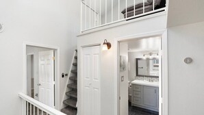 Eine Treppe führt zu einem Balkon im zweiten Stock mit Blick ins Freie.