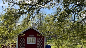 Un petit bâtiment en bois rouge, sur lequel est apposée une enseigne indiquant « KNOTEBO ».