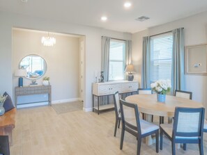 A dining area with a round table, chairs, a sideboard, and a mirror. - Oasis with Private Yard, Pool and Firepit in Desert Ridge - Close to Mayo! (Phoenix)