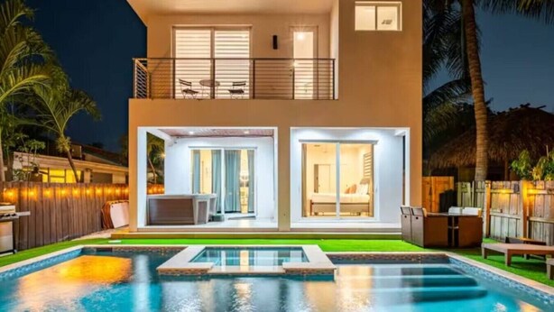 Et toetagers hus med swimmingpool, balkon og et lyst interiør.