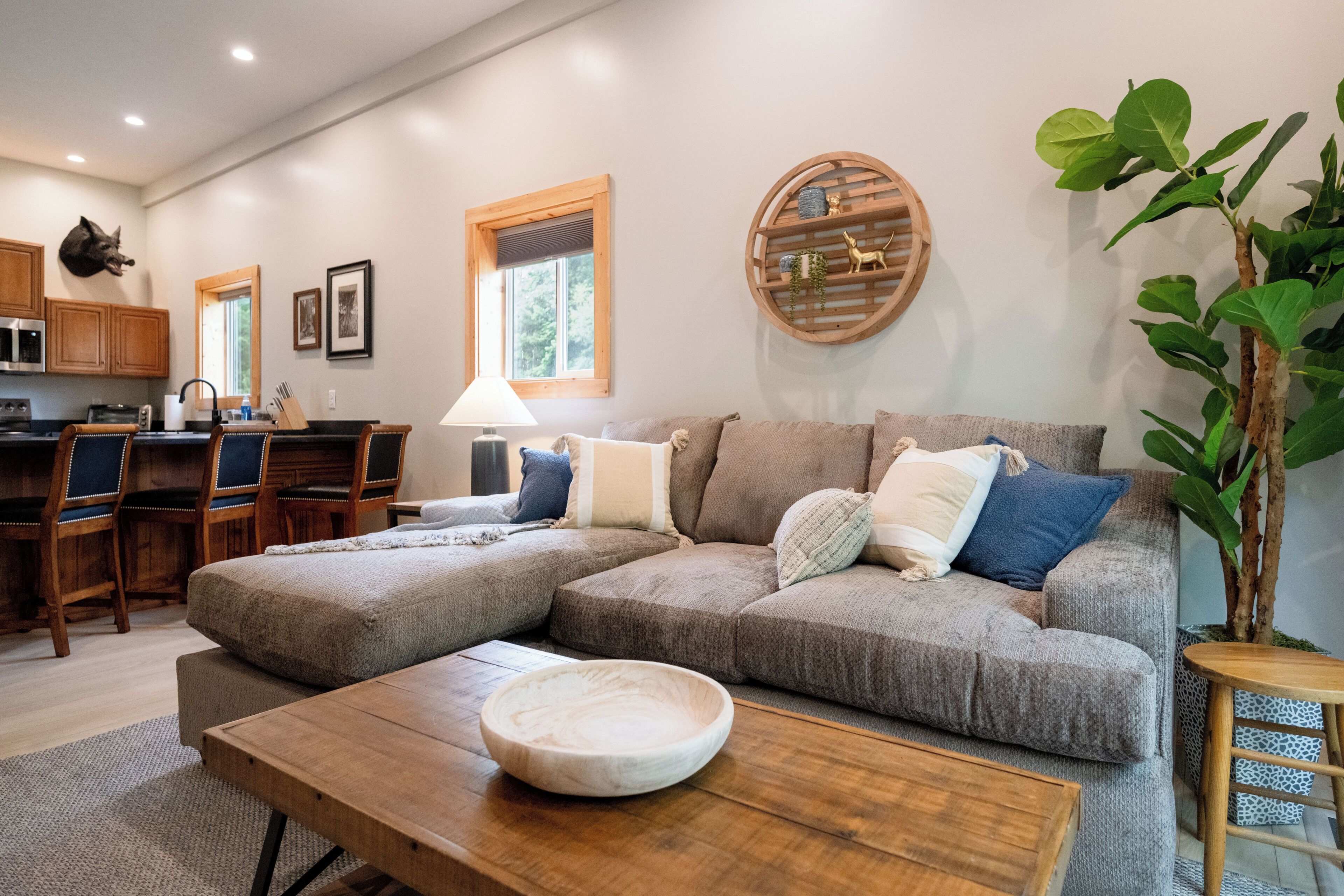 Una sala de estar con un sofá seccional, una mesa de centro de madera y un comedor con sillas y una mesa.