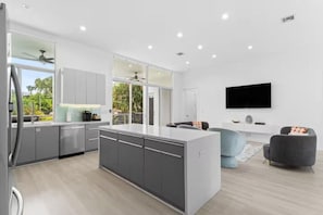 A modern kitchen with a central island, grey cabinetry, and a large window. - Modern Luxe 2021Built Heated Pool/Jacuzzi/Gameroom (Fort Lauderdale)