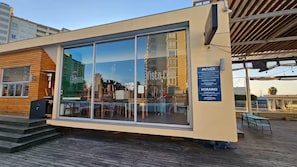 A modern building with large glass windows, a wooden facade, and a sign indicating it is a jacuzzi and spa.