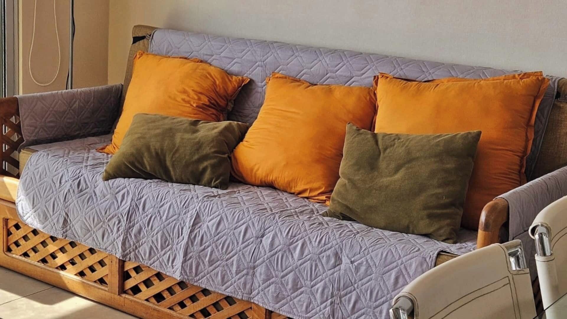 Ein Sofa mit gesteppter Bezug und mehreren Kissen in verschiedenen Farben.