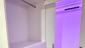 Een kamer met een inbouwkast, een houten vloer en een deur die naar een andere kamer leidt.
