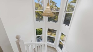 Un interior blanco con varias ventanas y una lámpara colgante.