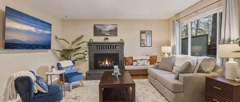 A living room with a fireplace, a sofa, a coffee table, and a TV.