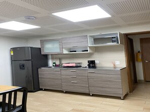 Eine moderne Küche mit Kühlschrank, Mikrowelle und Kaffeemaschine.