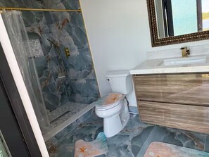 A bathroom with a marble floor, a toilet, a sink, and a mirror. - Naples Vacation Paradise -  Lake & Pool Views (Naples)